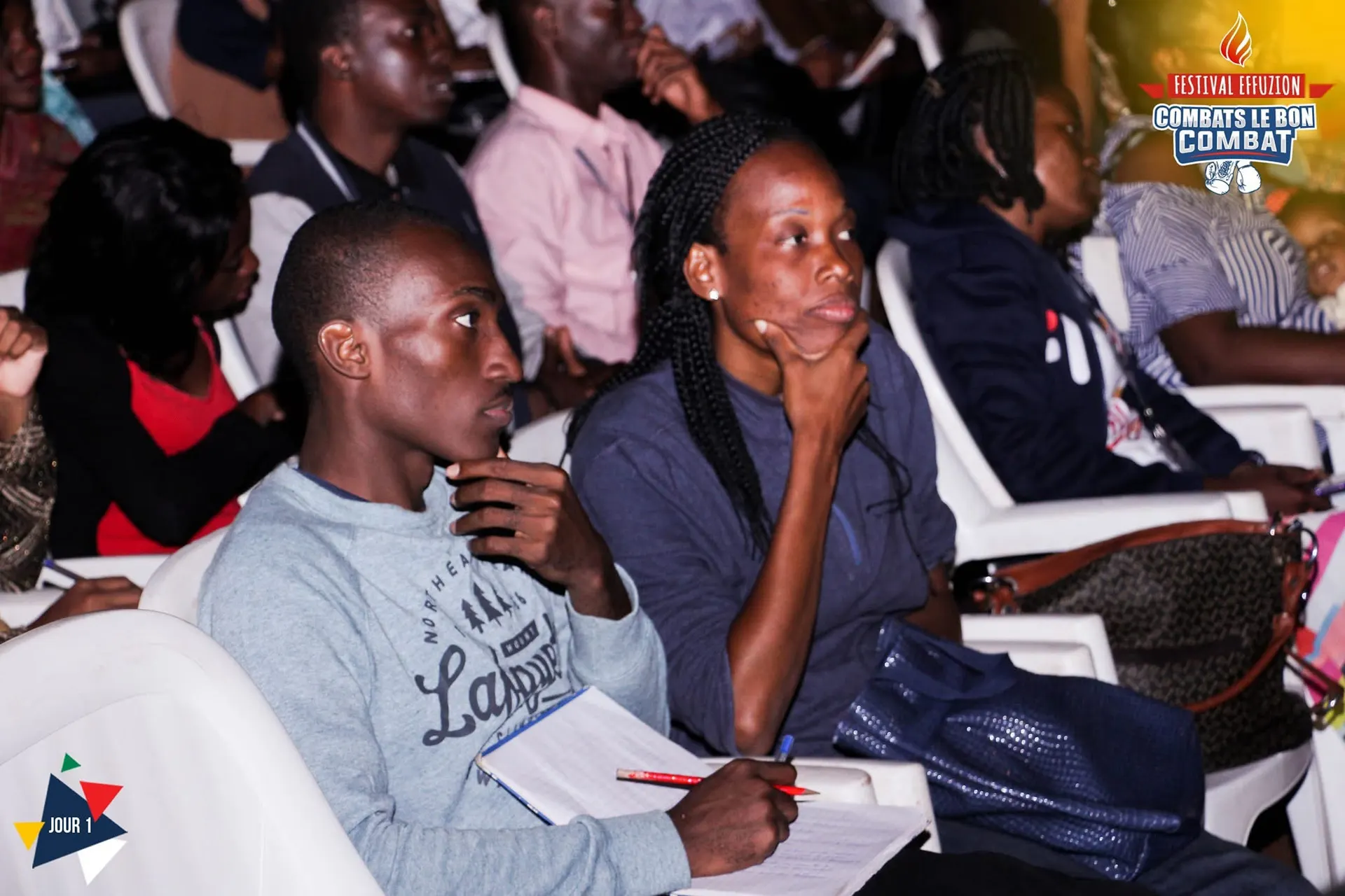 Le public assis écoute, carnets ouverts, pendant une conférence. Photo de l’événement Effuzion.