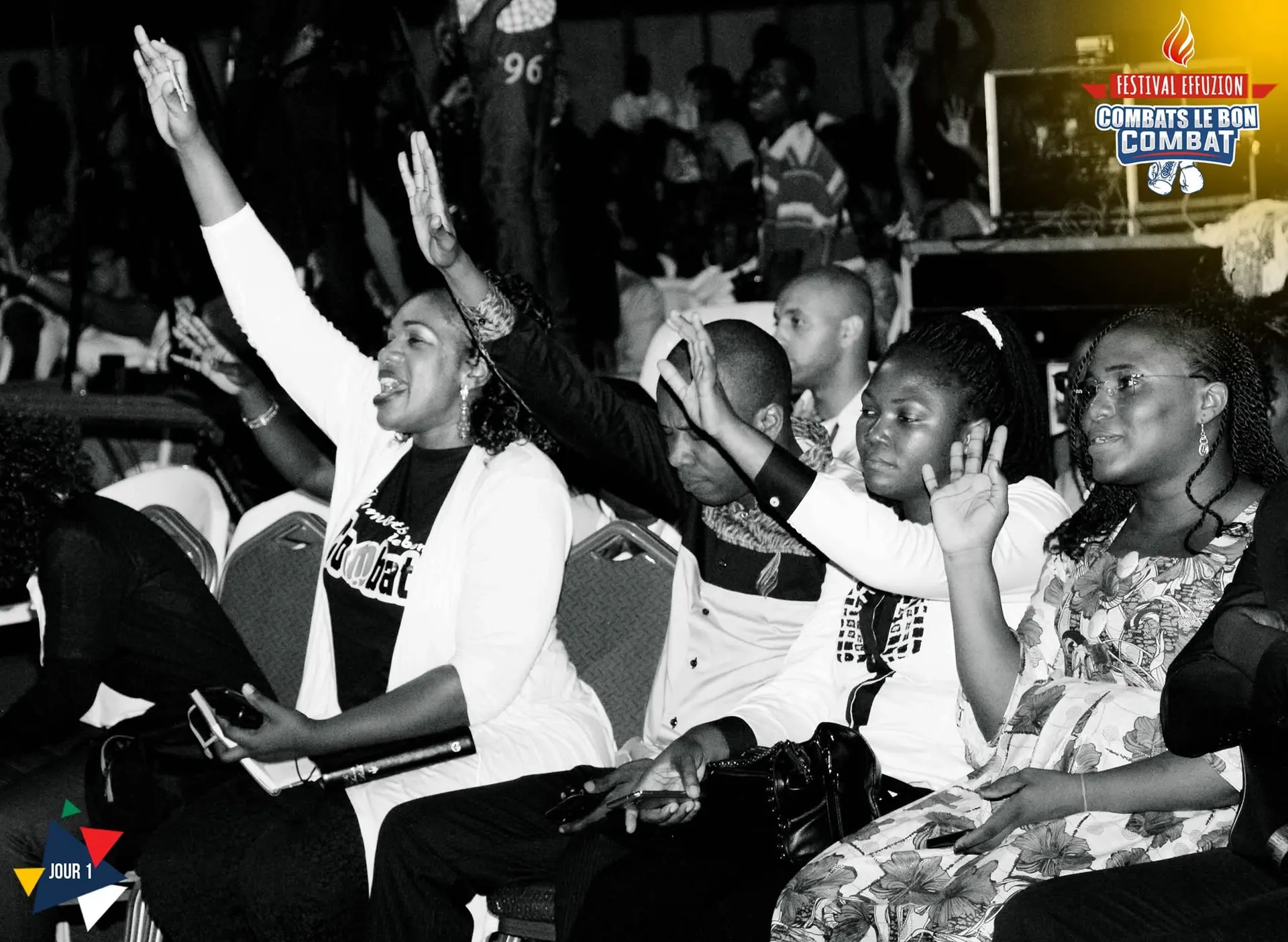En noir et blanc, des mains levées dans le public, des sourires. Photo de l’événement Effuzion.
