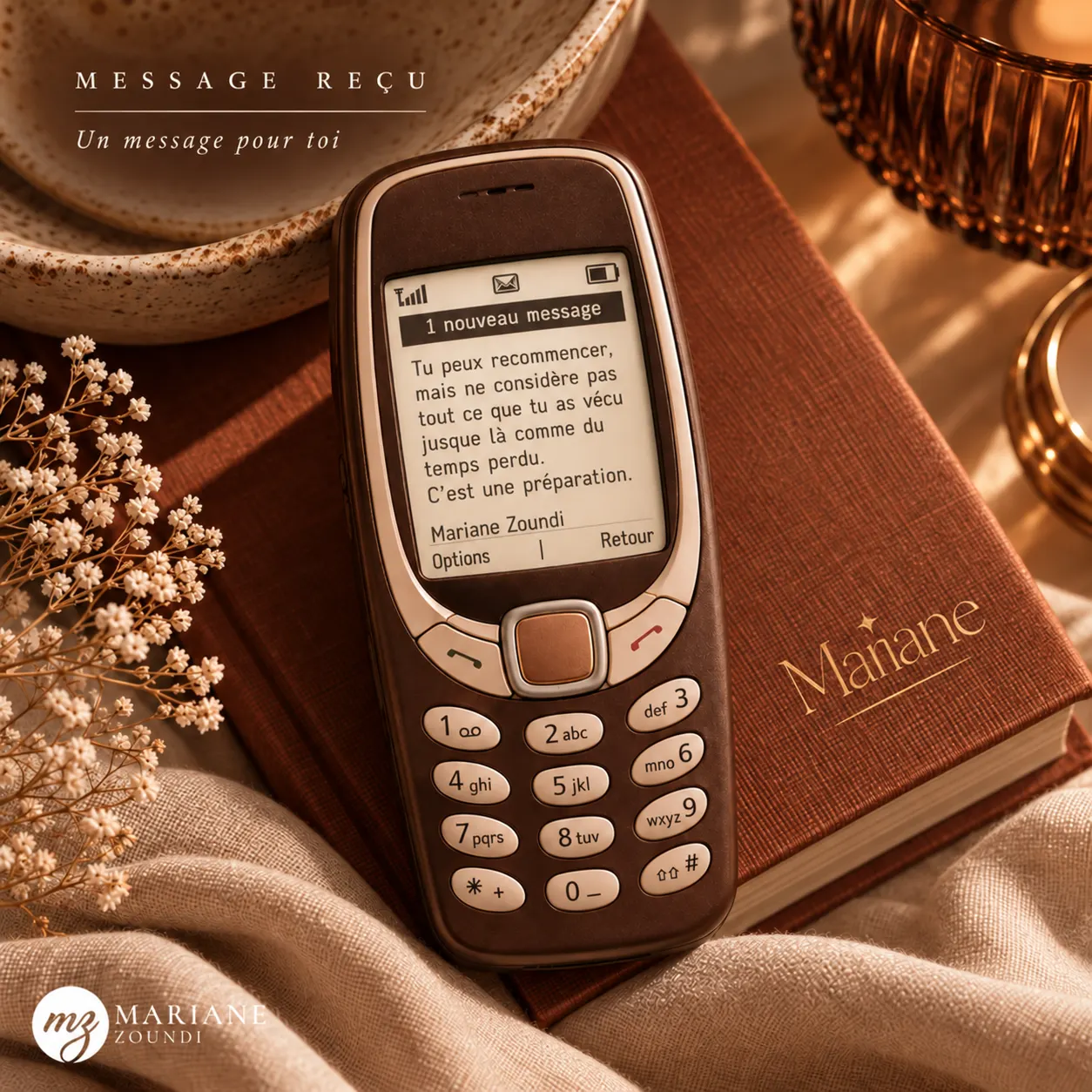 Visuel « Message reçu » : un ancien téléphone Nokia posé sur un livre affiche un message signé Mariane Zoundi.