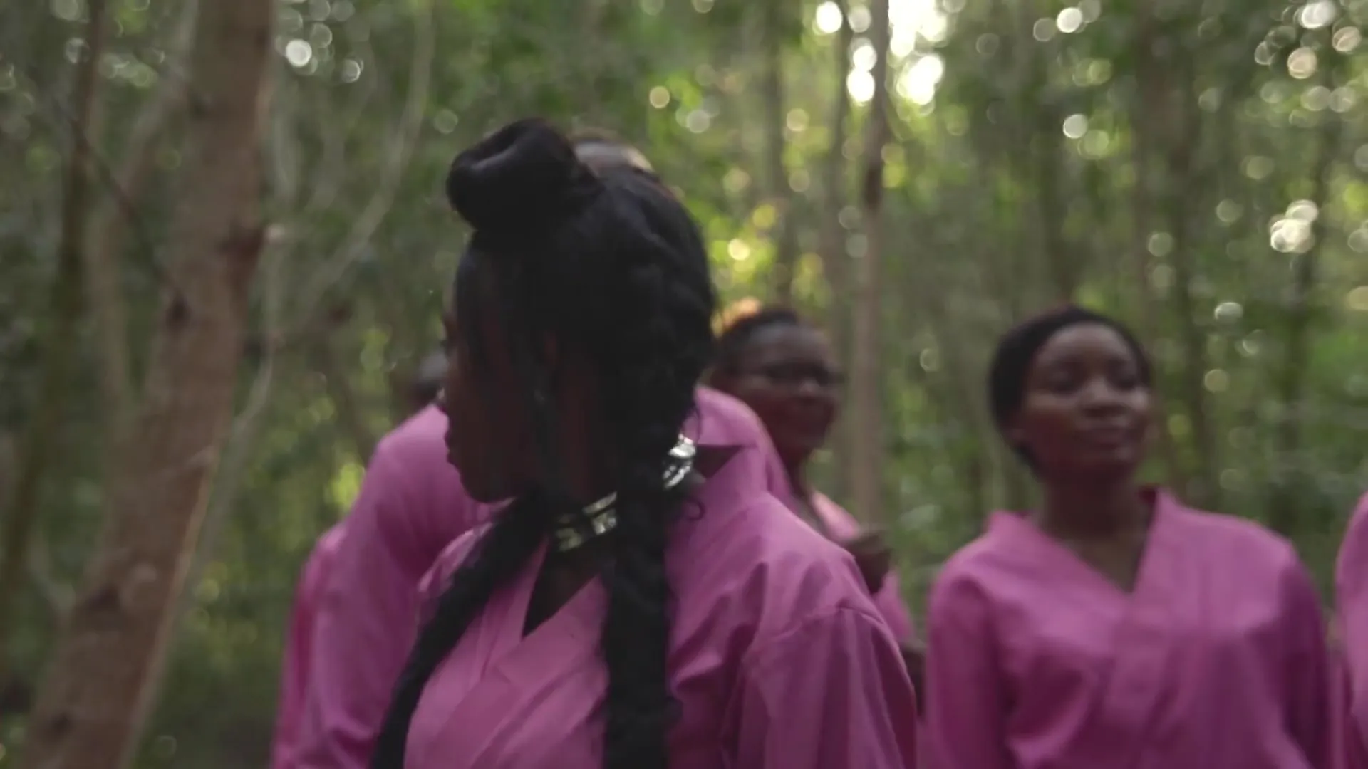 Une chanteuse aux longues tresses se retourne vers le chœur. Image extraite du clip officiel.