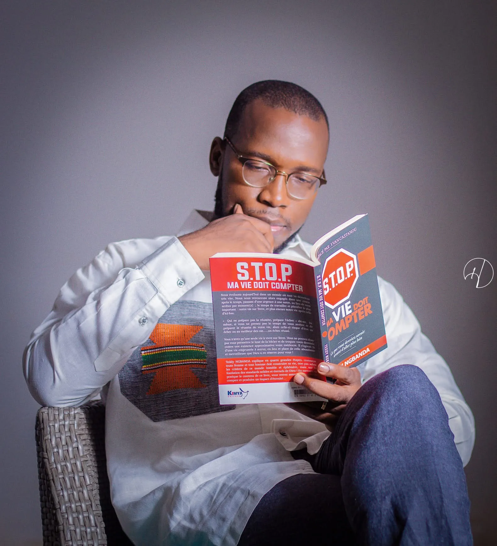 Un homme lit le livre S.T.O.P., la main sous le menton. Photo de terrain de la campagne.